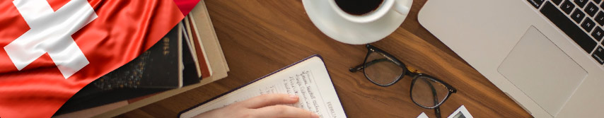 manos en computador con libreta de apuntes un café