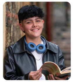 Estudiante sonriendo y sosteniendo un libto