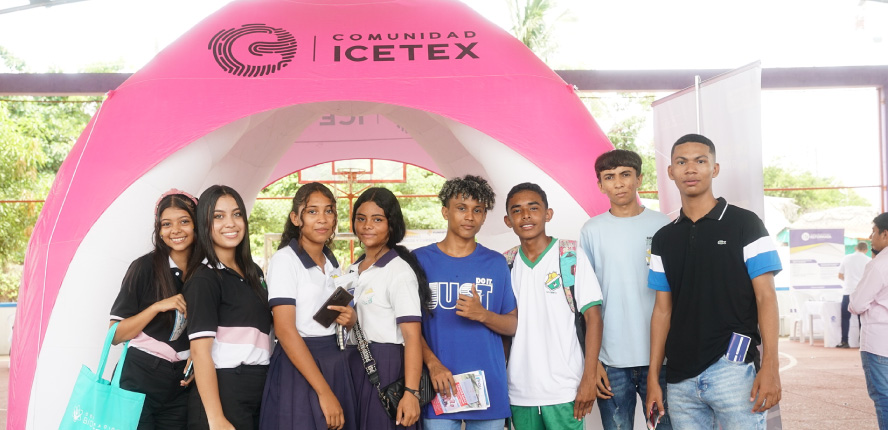 Foto plano general de estudiantes de colegio y de fondo la carpa de Comunidad ICETEX