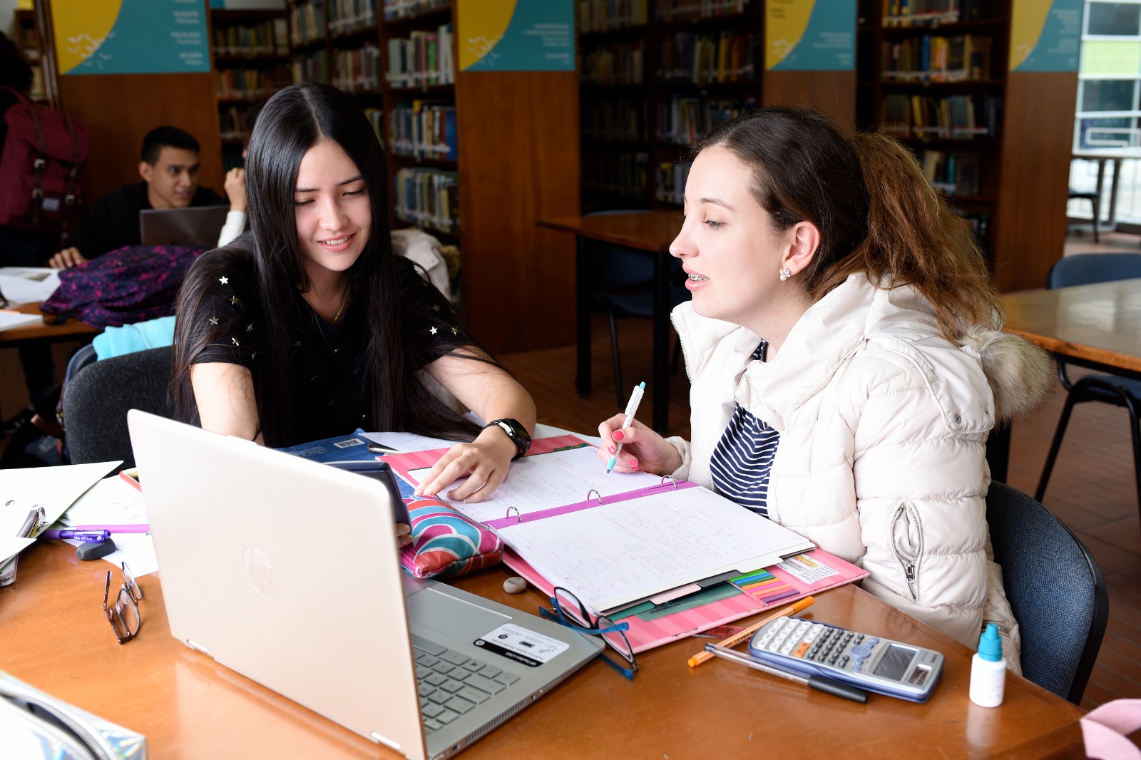 Foto estudiantes universitarios en biblioteca leyendo libros