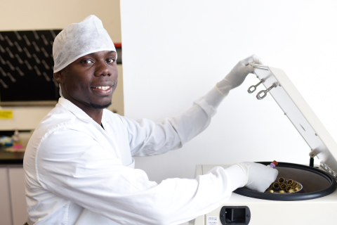 Persona afro sonriendo en un laboratorio