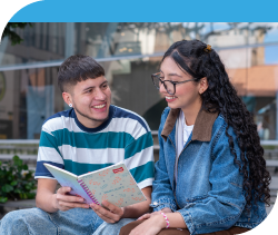 Jóvenes en la universidad sonriendo y leyendo un documento