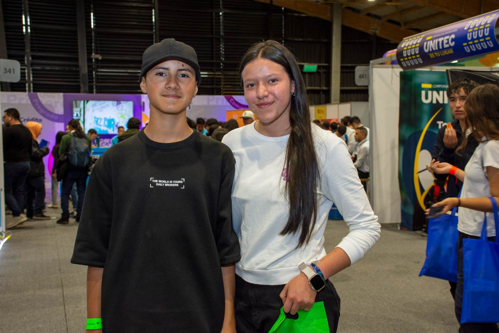 Imagen de dos estudiantes sonriendo a la cámara mientras están en un evento de ICETEX