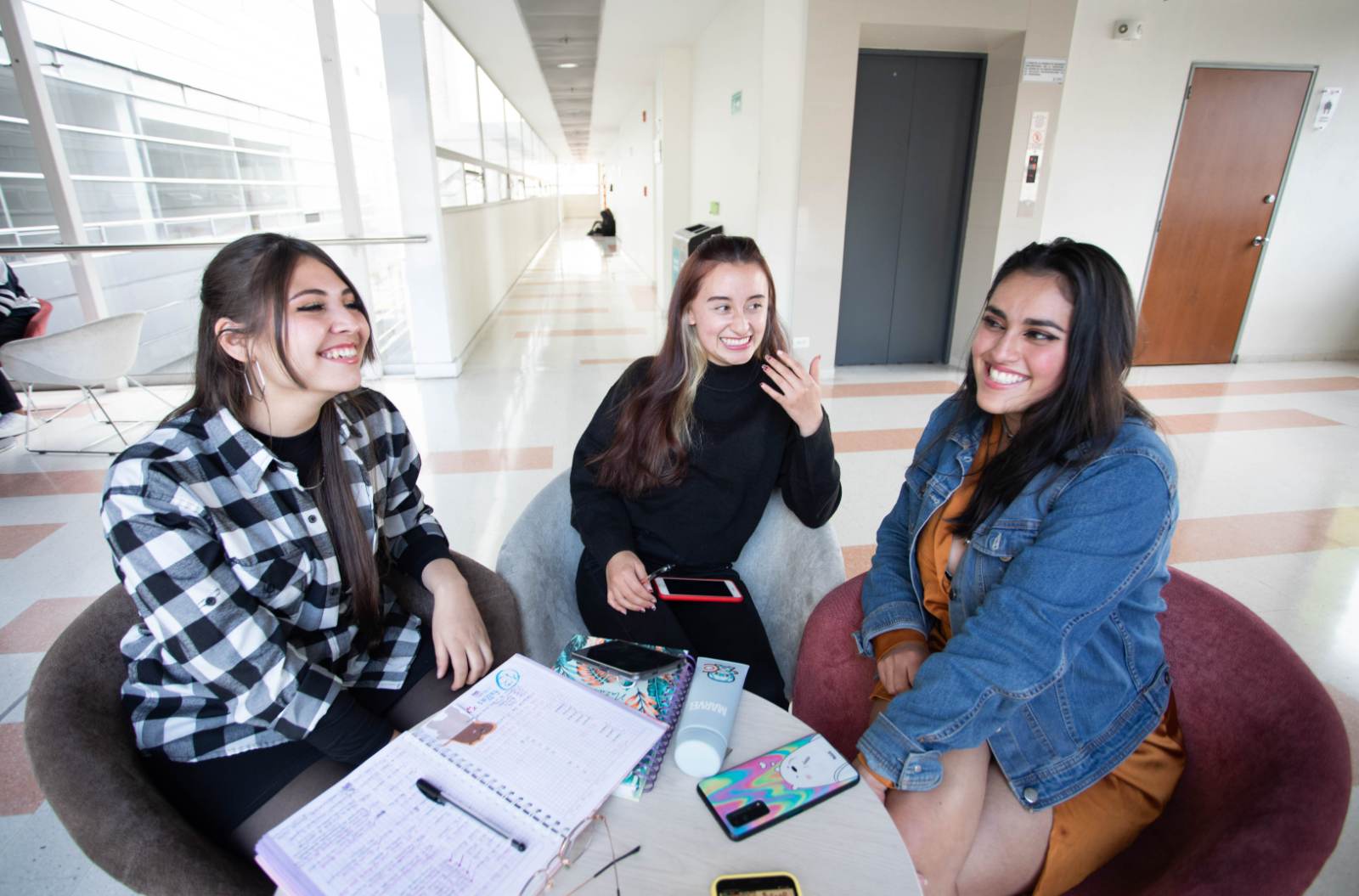 Imagen de estudiantes sentados sonriendo mientras hablan