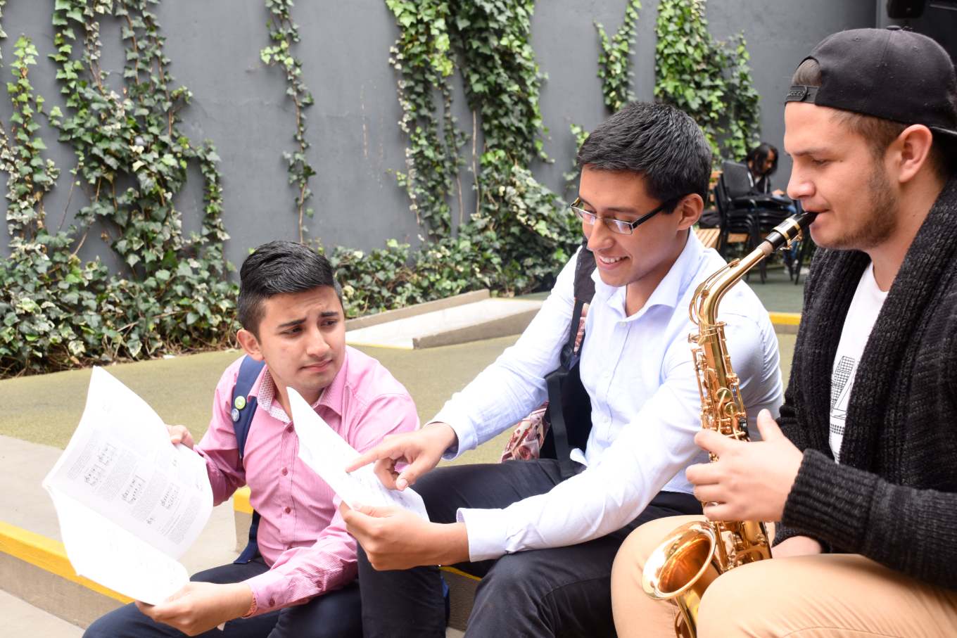 Estudiantes tocando saxofón y leyendo notas musicales