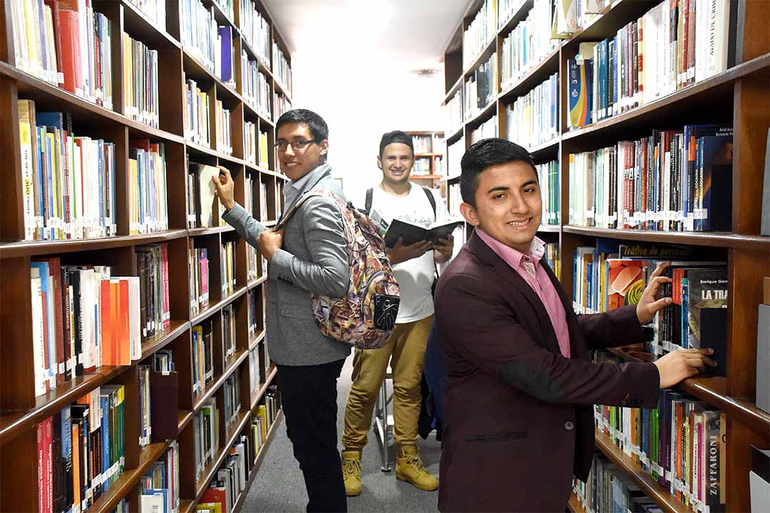 Imagen de beneficiarios de ICETEX sonriendo en una biblioteca