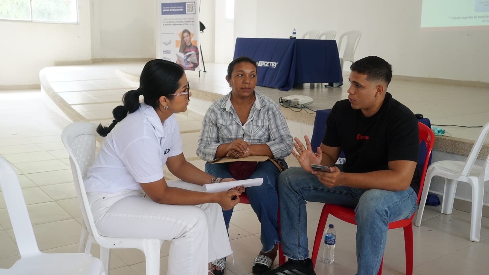 Imagen de estudiante con su padre hablando con personal del ICETEX