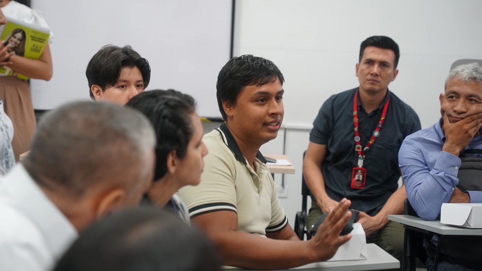 Imagen de estudiante hablando acompan¿ado de adultos mayores
