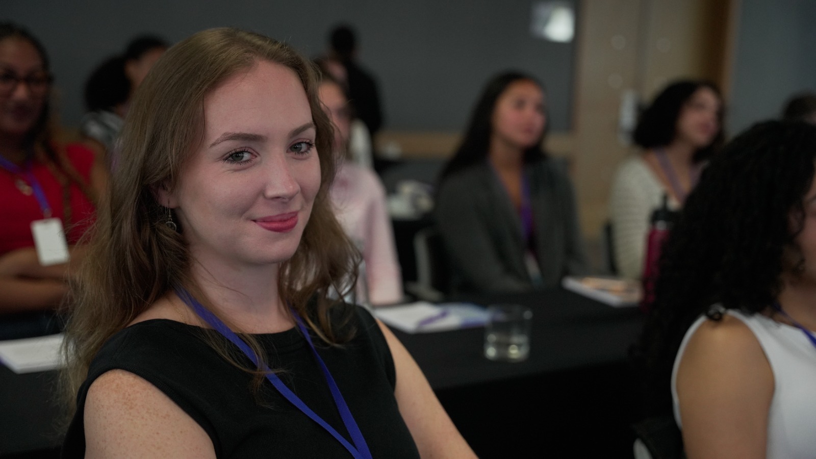Imagen de mujer sonriendo mientras asiste a un evento de ICETEX