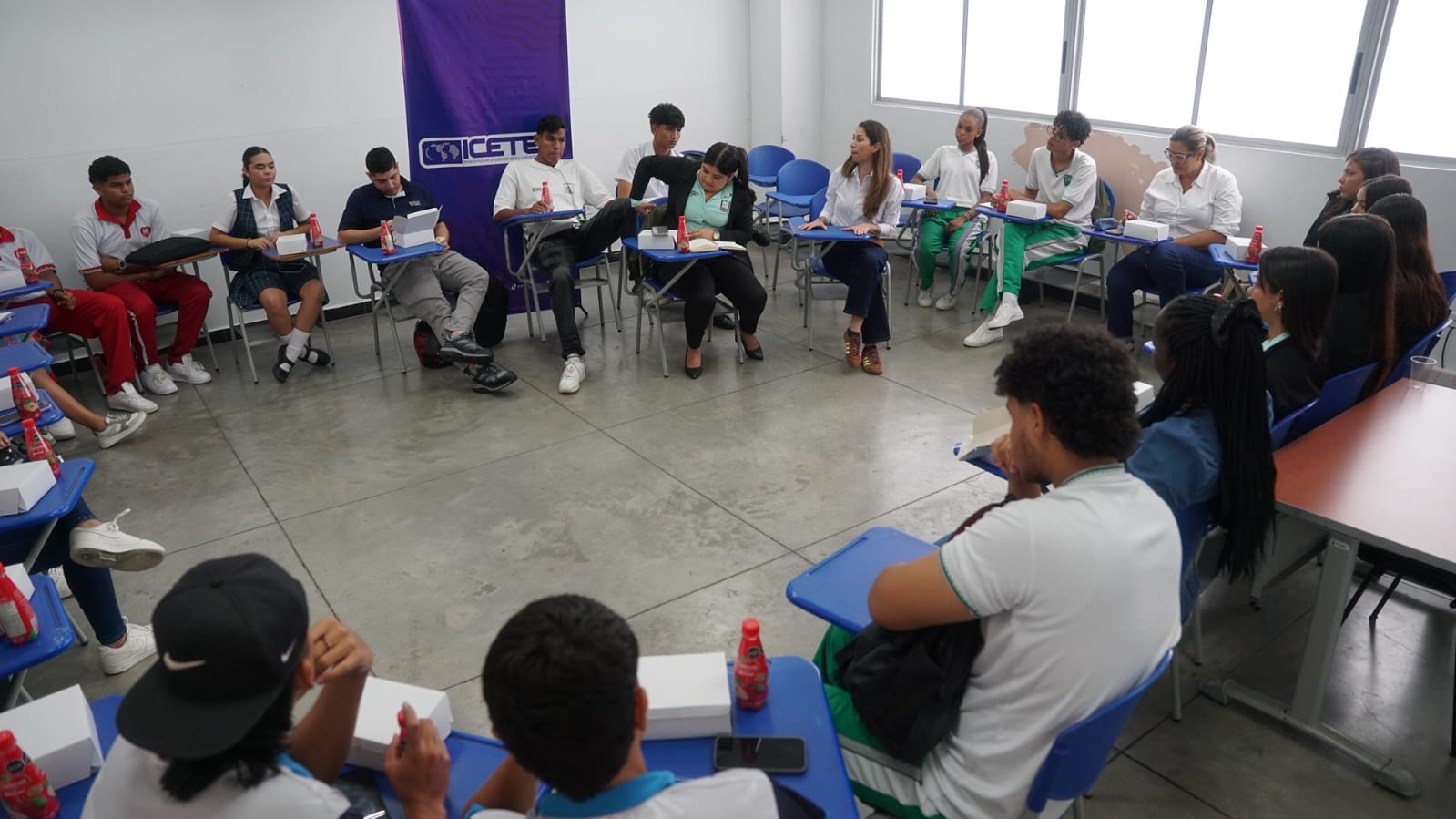 Imagen de personal del ICETEX y estudiantes conversando en una mesa redonda en colegio