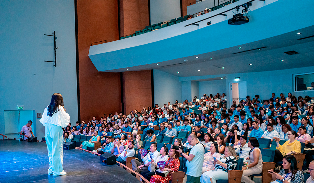 Imagen de persona presentando ante publico en auditorio