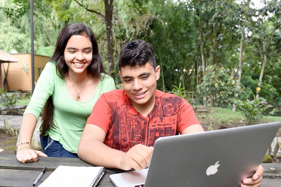 Jóvenes sonriendo usando el computador