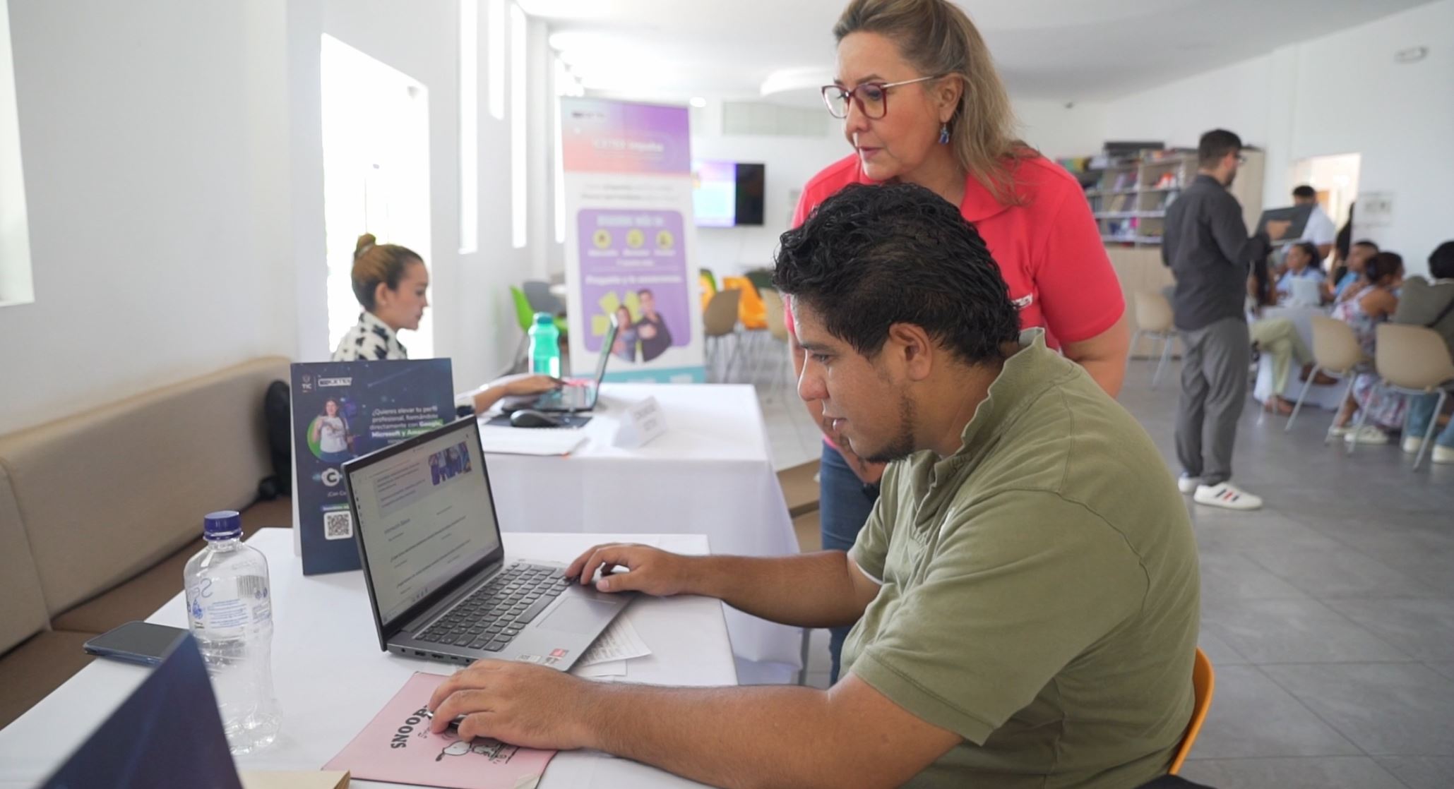 Mujer territorial de ICETEX acompañando a ciudadano en la navegación por página web de ICETEX