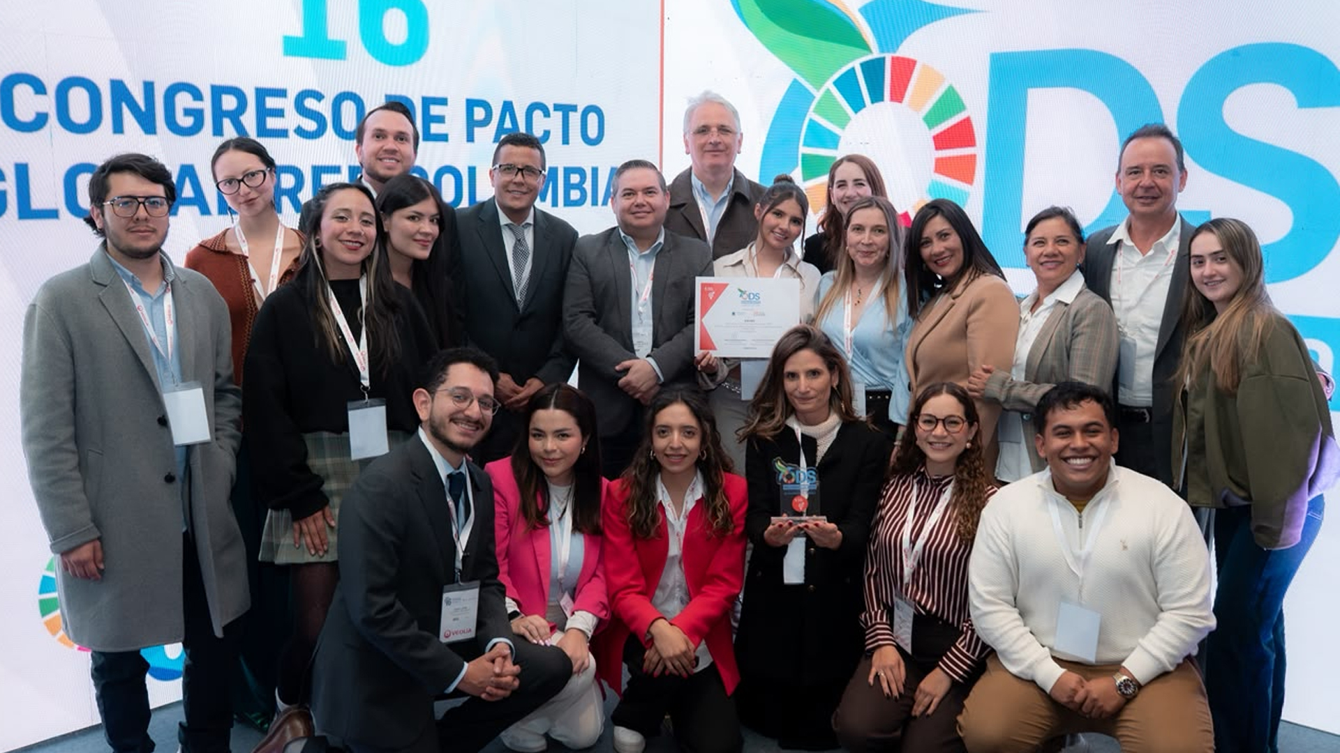 Fotografía grupal del equipo de ICETEX recibiendo el Reconocimiento a las buenas prácticas de desarrollo sostenible ODS 5, sosteniendo el diploma y el trofeo en el marco del congreso de pacto global