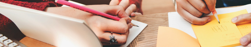 Plano medio contrapicado de dos estudiantes escribiendo en cuadernos