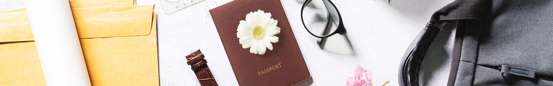 Plano general de pasaporta, gafas, maleta, reloj y sobres de manila