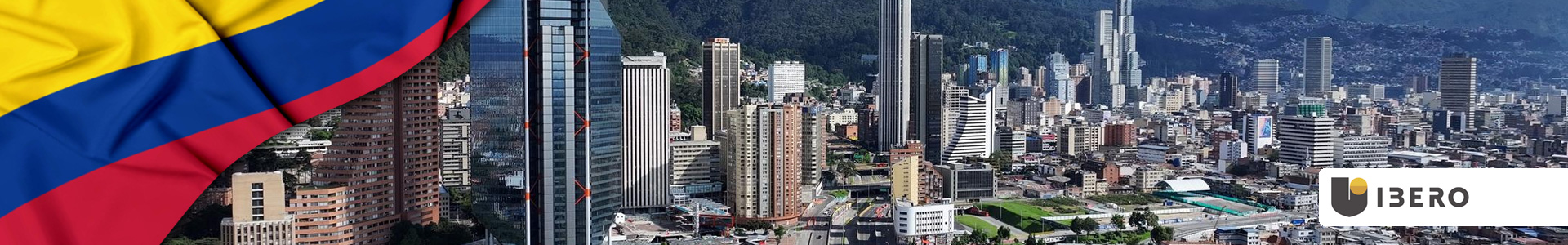 Bandera de Colombia ondeando con vista al horizonte de Bogotá y edificios modernos