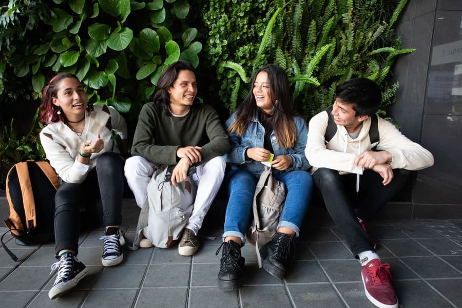 jóvenes felices al conocer las becas en Japón, en un ambiente universitario.